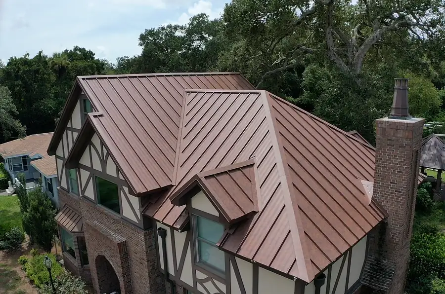 Standing seam metal roof with ridge and roof junction flashings on a two-storey house in Sydney. 
